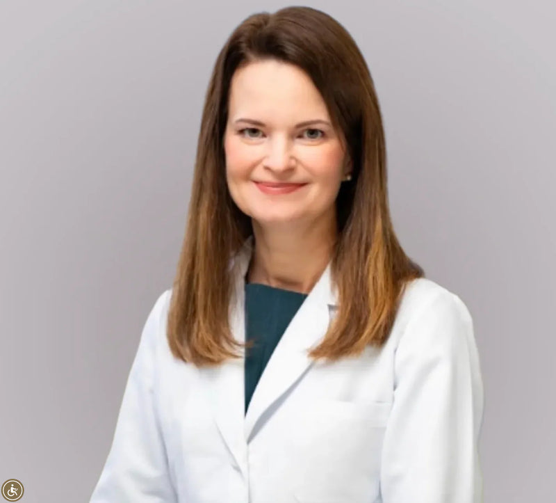 Dr. Anastasia Brown, Aesthetic Supervising Physician at ARMÉ, photographed in a white lab coat over a dark teal top.